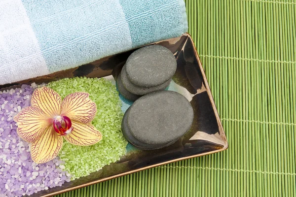 Spa concept with mineral bath salt, massage stones, towel and or — Stock Photo, Image