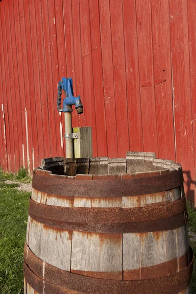 赤い納屋の横にある古い木製の樽. — ストック写真