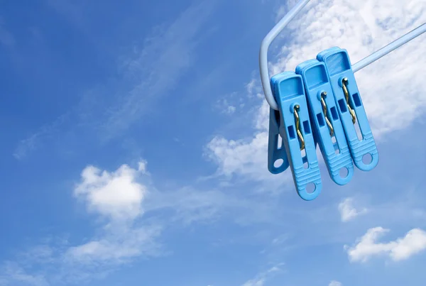 Kläder pin clip på blå himmel bakgrund — Stockfoto