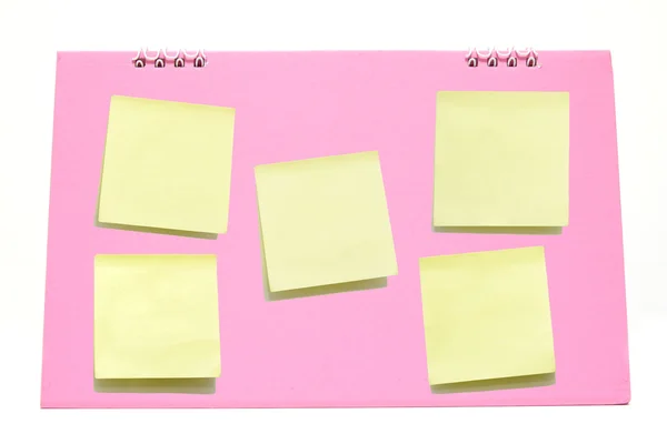 Żółte notatki kij na kalendarz różowy — Zdjęcie stockowe