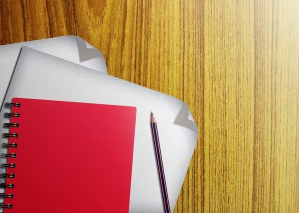 Rotes Notizbuch und weißes Papier mit Bleistiften auf hölzernem Hintergrund — Stockfoto