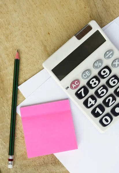 Stock image White paper with calculator pencil and memo on wood table