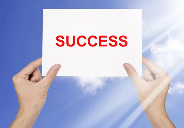 Geschäftsmann hält weißes Papier und das Wort Erfolg auf blauem Grund — Stockfoto