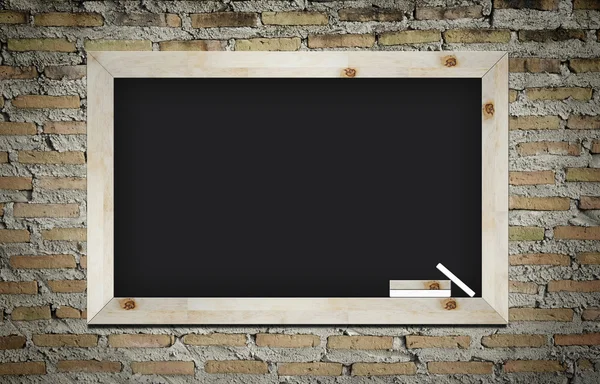 Leeg bord met houten frame en krijtjes op muur achtergrond — Stockfoto