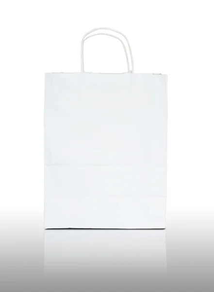 Saco de papel branco em refletir chão e fundo branco — Fotografia de Stock