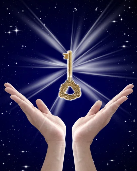 stock image The key to success (hand holding key against night sky)