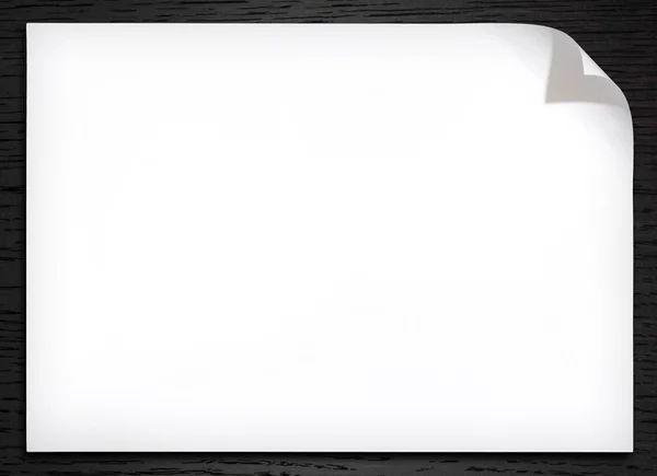 Papel blanco en blanco con rizo de esquina sobre el fondo de madera oscura —  Fotos de Stock