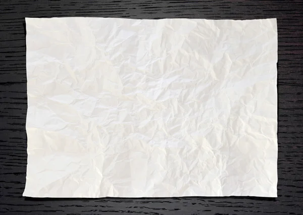Wrinkled White paper on dark wood background — Stock Photo, Image