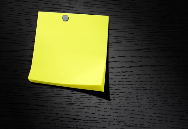 Uwaga żółty papier na ciemnym tle drewna — Zdjęcie stockowe