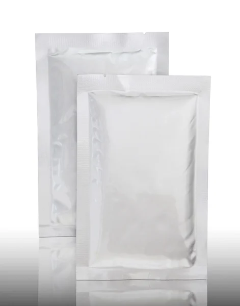 Kunststoffverpackung auf spiegelndem Boden und weißem Hintergrund — Stockfoto