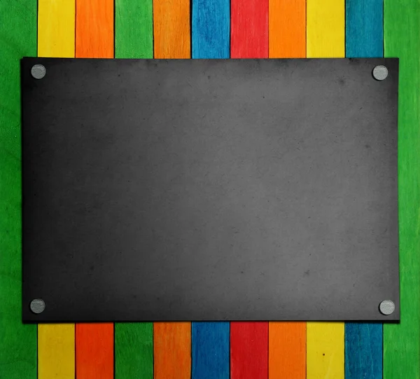 Renkli ahşap arka plan üzerinde siyah kağıt — Stok fotoğraf