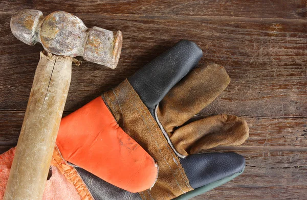 Viejo Martillo y guantes de cuero sobre fondo de madera —  Fotos de Stock
