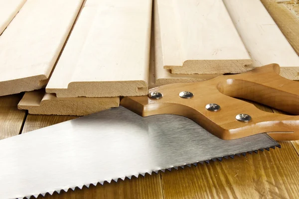 La sierra de carpintero está sobre tablones de madera — Foto de Stock