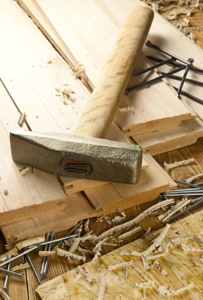 Hamer en nagels zijn op een houten planken — Stockfoto