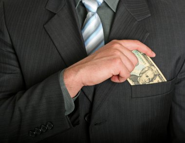 Businessman putting a dollar bill in his pocket clipart