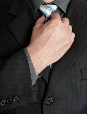 Businessman tweaking his tie clipart