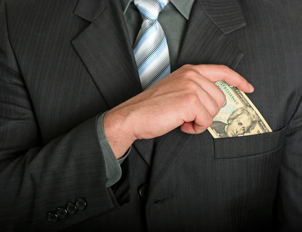 Homme d'affaires mettre un billet d'un dollar dans sa poche — Photo