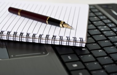 Pen, notepad and laptop on the desk clipart