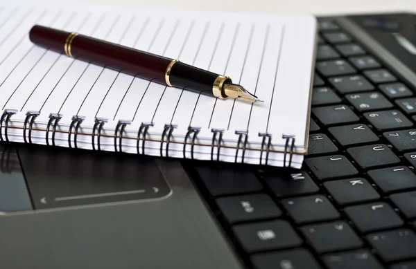 Penna, anteckningsblock och laptop på skrivbordet — Stockfoto