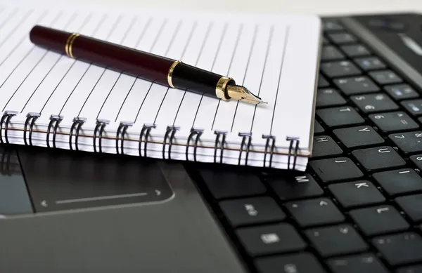 Penna, blocco note e laptop sulla scrivania Immagini Stock Royalty Free