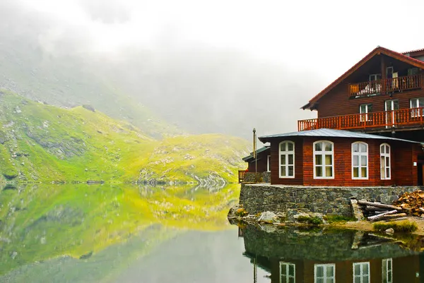 Casa junto al lago en las montañas, Cárpatos, Rumania, Europa — Foto de Stock