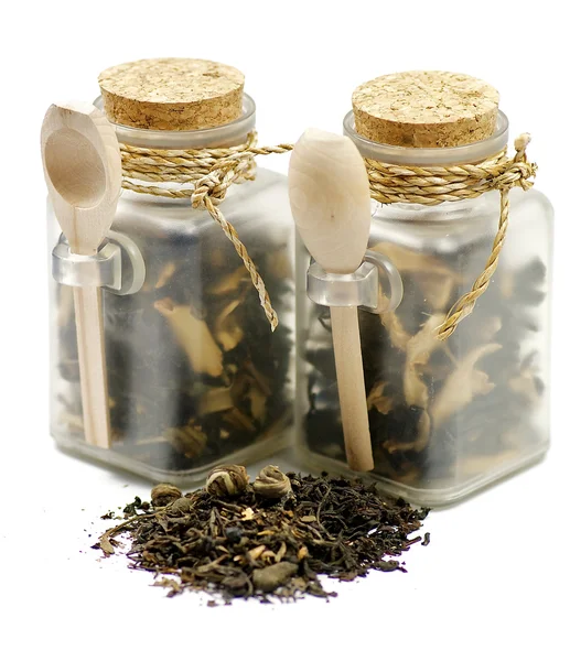 Tea leaves in transparent parisons with wooden spoon — Stock Photo, Image