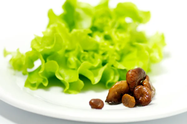 Pfifferlinge Pilze mit Salatblättern isoliert auf weißem Hintergrund — Stockfoto