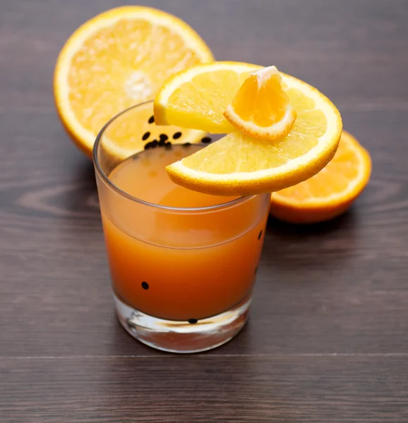 Färsk apelsinjuice med apelsinskivor på trä bakgrund — Stockfoto