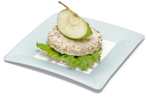Gramineae Crispbread with Salad leaves and apple isolated on blue plate — Stock Photo, Image