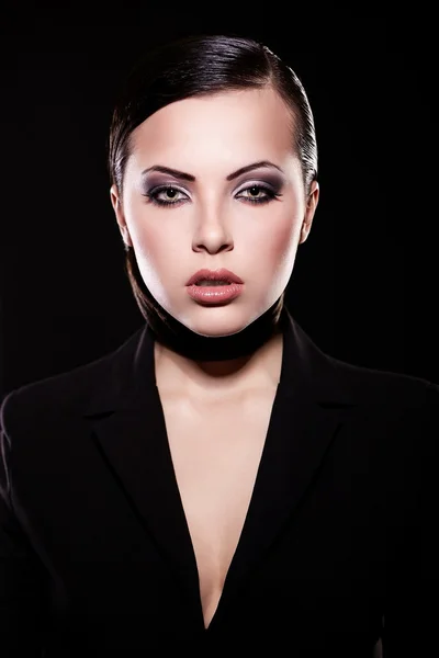 High fashion blik. Portret van mooie brunette meisje model in zwarte jas met lichte make-up en sappige lippen. huid schoon. geïsoleerd op zwart — Stockfoto