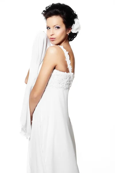 Felice sexy bella sposa ragazza bruna in abito da sposa bianco con acconciatura e trucco luminoso con fiore in capelli isolati su bianco — Foto Stock