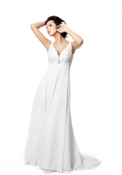 Joyeux sexy belle mariée fille brune en robe de mariée blanche avec coiffure et maquillage lumineux avec fleur dans les cheveux isolés sur blanc — Photo