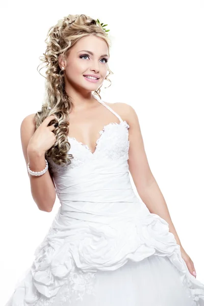 Щаслива усміхнена красива наречена блондинка в білій весільній сукні з зачіскою і яскравим макіяжем на білому тлі — стокове фото