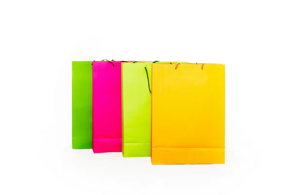 Assorted colored shopping bags including yellow, orange, pink and green on a white background — Stock Photo, Image