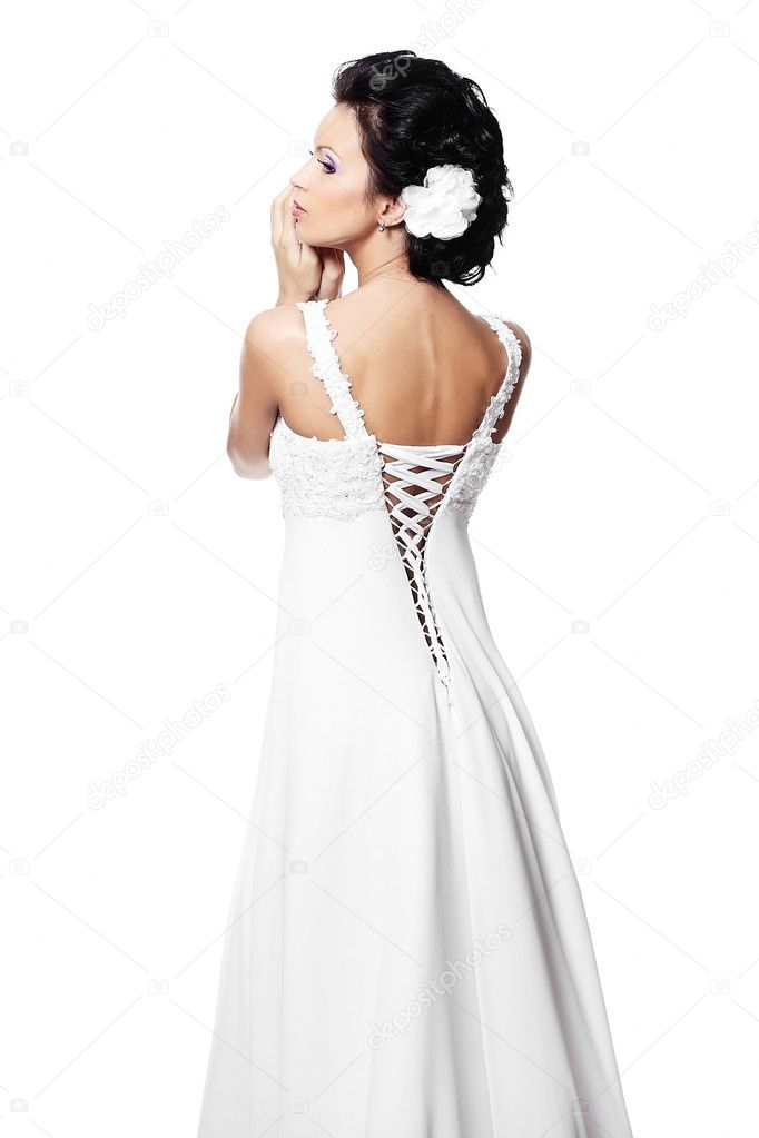 Back of happy sexy beautiful bride brunette girl in white wedding dress with hairstyle and bright makeup with flower in hair isolated on white