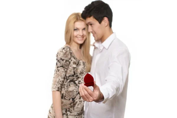 Junger romantischer, gutaussehender Mann präsentiert Schmuck in einem attraktiven roten Etui, um — Stockfoto