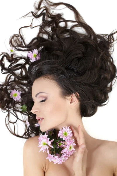 Bastante hermosa chica acostada con flores brillantes en su pelo maquillaje brillante —  Fotos de Stock