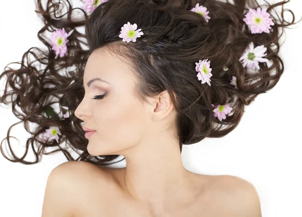 Bastante hermosa chica acostada con flores brillantes en su pelo maquillaje brillante —  Fotos de Stock