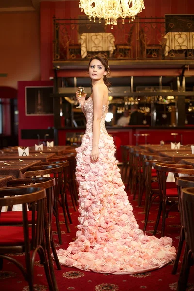Bela noiva em vestido de noiva incomum no restaurante com xícara de vinho — Fotografia de Stock