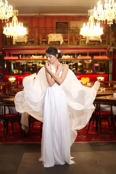 Beautiful bride in flying wedding dress in the restaurant — Stock Photo, Image