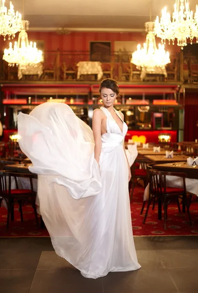 Bella sposa in abito da sposa volante nel ristorante — Foto Stock