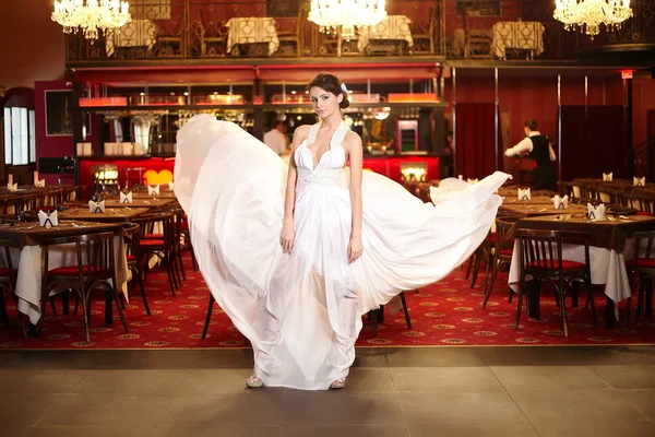 Indah pengantin dalam terbang gaun pengantin di restoran — Stok Foto