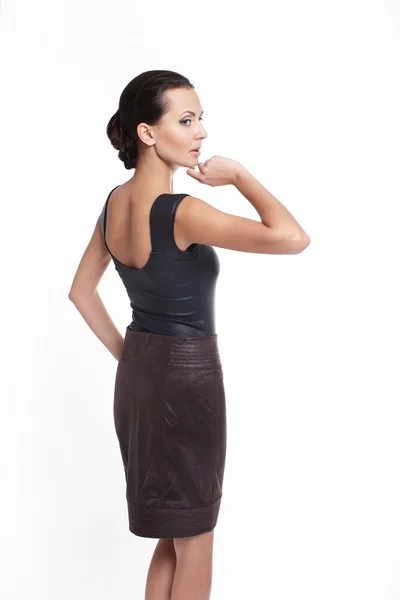 Powrót młodych piękne sexy kobieta w spódnicy brązowy na białym tle — Zdjęcie stockowe
