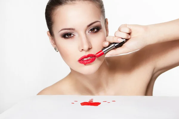 Närbild porträtt av sexiga kaukasiska ung kvinna modell med glamour röda läppar, ljusa makeup, pil ögonmakeup, renhet hy med rött läppstift. perfekt ren hud. blod på tabell — Stockfoto