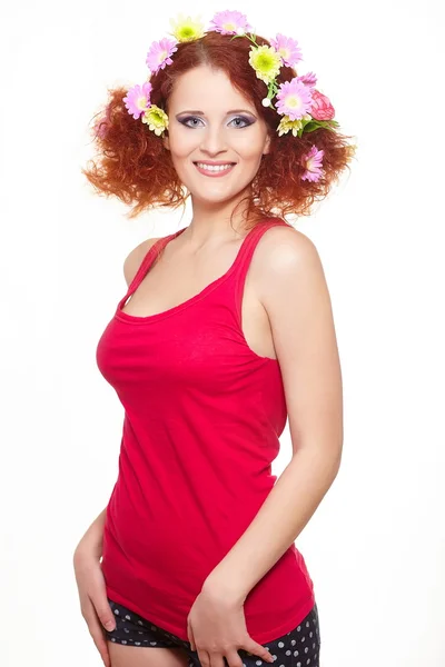 Porträtt av vackra leende rödhårig ingefära kvinna i röd duk med gula rosa färgglada blommor i håret isolerad på vit med citron i händer — Stockfoto