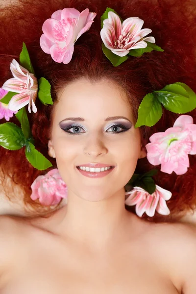 Primer plano retrato de hermosa sonrisa pelirroja pelirroja mujer cara con flores de colores en el pelo en porofile —  Fotos de Stock