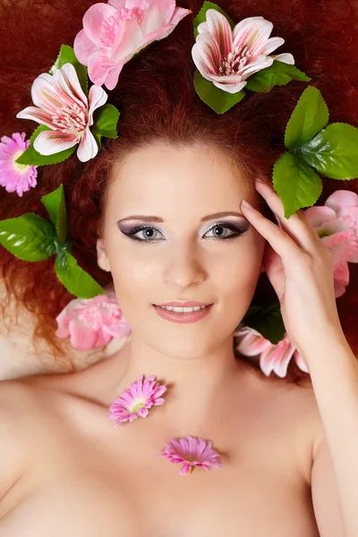 Closeup portrait of beautiful smiling redhead ginger woman face with colorful flowers in hair in porofile — Stock Photo, Image