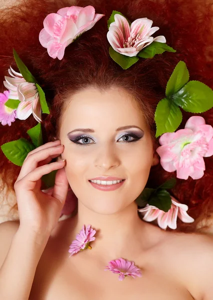 Retrato de close-up de belo sorriso ruiva ruiva mulher rosto com flores coloridas no cabelo em porofile — Fotografia de Stock