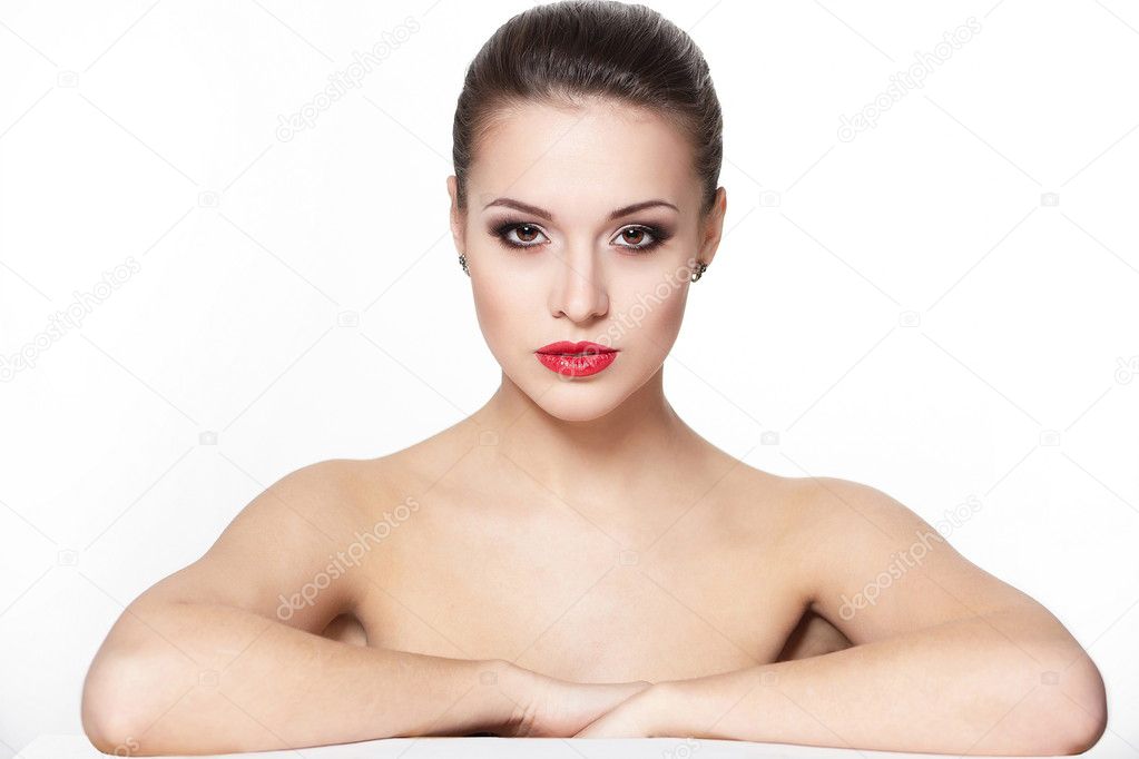 Portrait of sexy serious sitting caucasian young woman model with glamour red lips,bright makeup, eye arrow makeup, purity complexion. Perfect clean skin