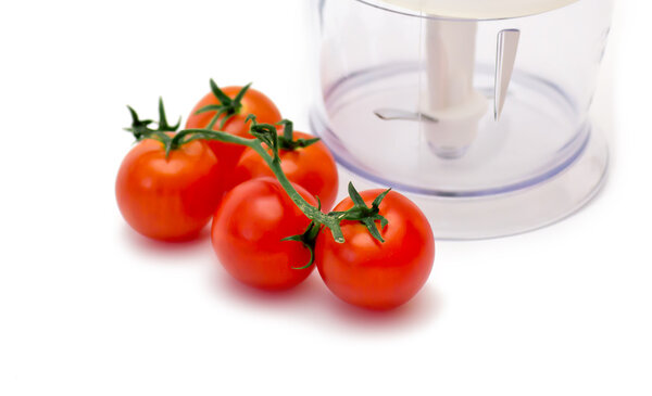 Chopper and tomatoes on a white background